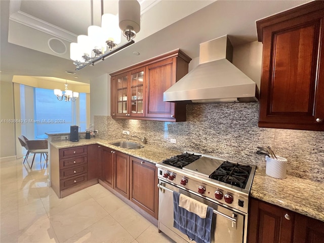 kitchen with tasteful backsplash, an inviting chandelier, high end range, and wall chimney range hood