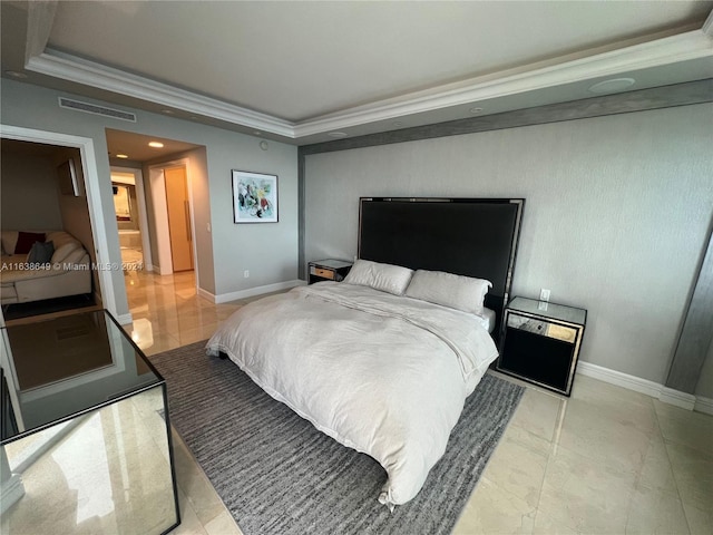 bedroom with a tray ceiling, baseboards, visible vents, and crown molding