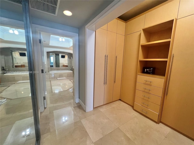 hallway with baseboards and visible vents