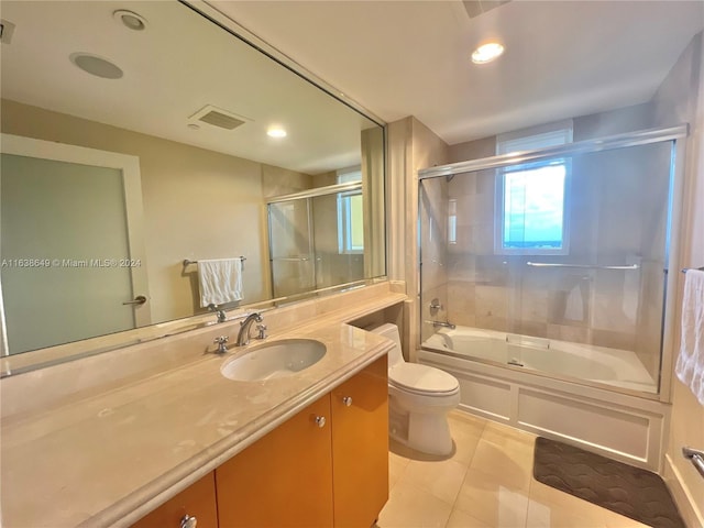 full bathroom with visible vents, toilet, combined bath / shower with glass door, tile patterned flooring, and vanity