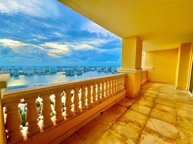 balcony featuring a water view and a city view