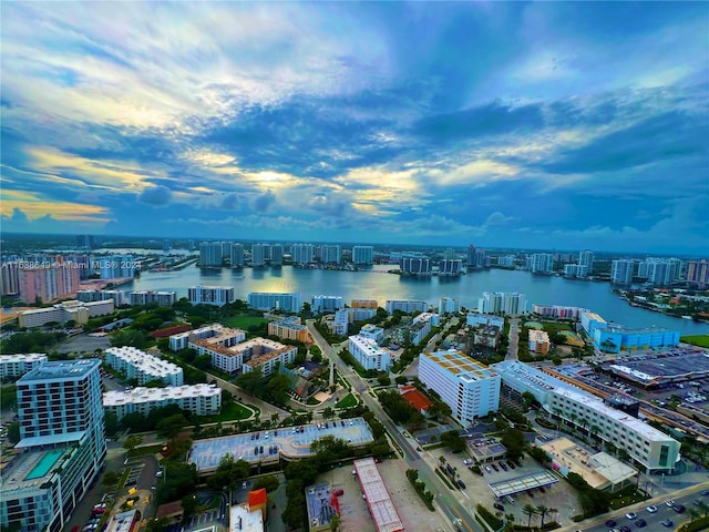 aerial view at dusk featuring a water view