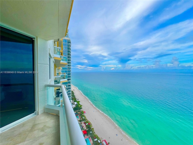 balcony featuring a water view and a beach view