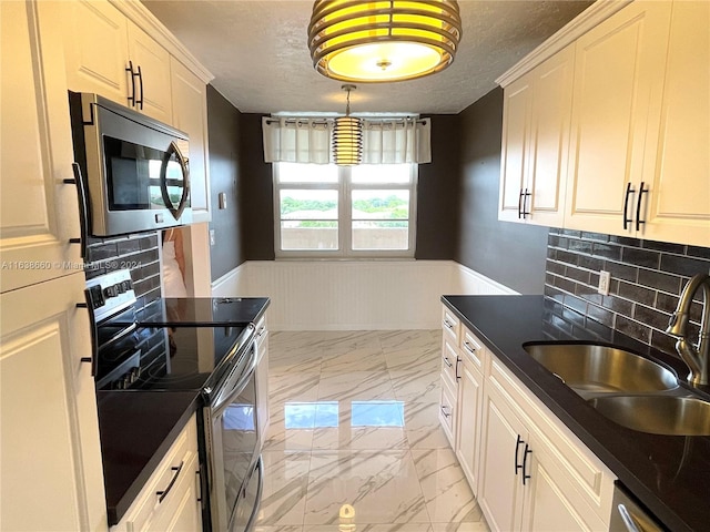 kitchen with light tile patterned flooring, sink, range with two ovens, and backsplash