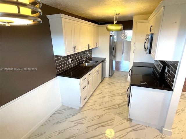 kitchen with appliances with stainless steel finishes, hanging light fixtures, light tile patterned floors, tasteful backsplash, and sink