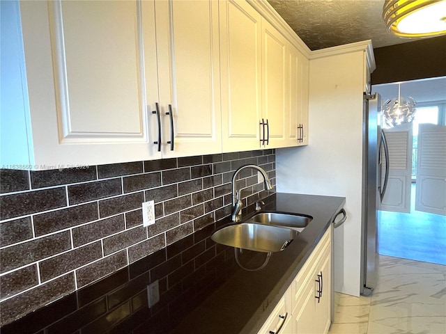 kitchen featuring tasteful backsplash, a textured ceiling, stainless steel refrigerator, light tile patterned floors, and sink