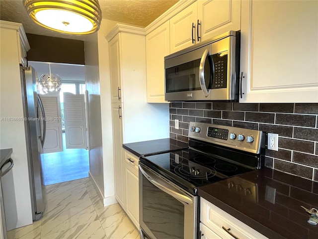 kitchen with tasteful backsplash, light tile patterned floors, stainless steel appliances, and white cabinetry