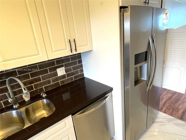 kitchen with sink, tasteful backsplash, light hardwood / wood-style flooring, and stainless steel appliances