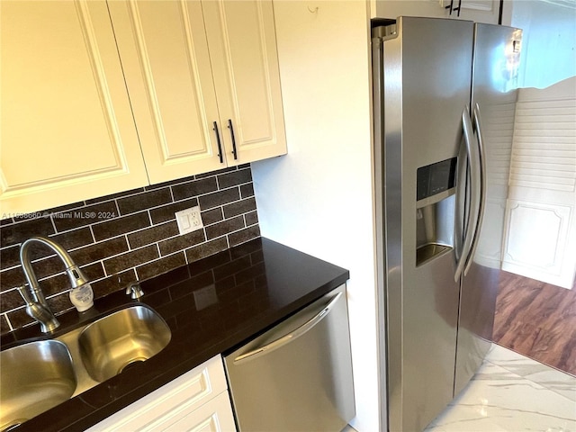 kitchen featuring stainless steel appliances, dark countertops, a sink, and decorative backsplash