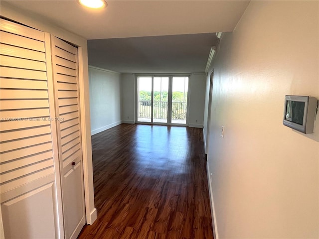 corridor with baseboards and dark wood-type flooring