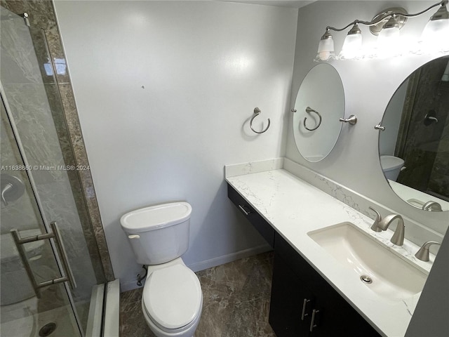 bathroom with toilet, a stall shower, vanity, and baseboards