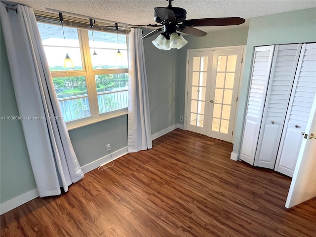 unfurnished bedroom with a textured ceiling, french doors, dark hardwood / wood-style flooring, and ceiling fan