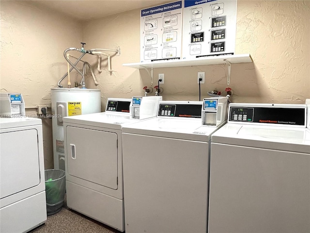 community laundry room featuring water heater, washer and dryer, and a textured wall