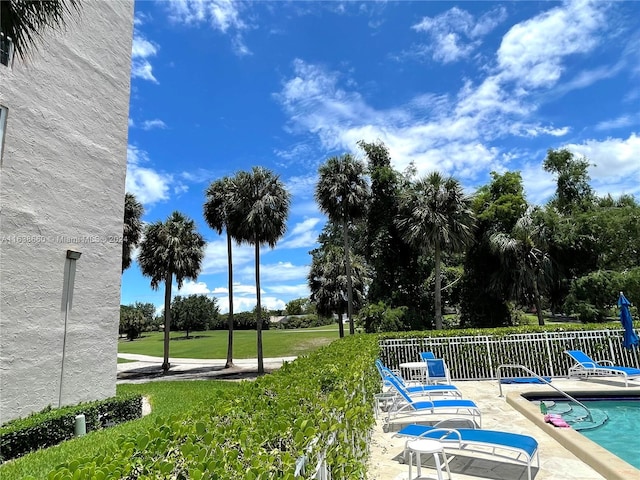 view of swimming pool featuring a patio area and a yard