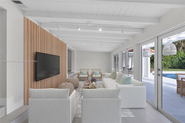 living room featuring beam ceiling, light hardwood / wood-style flooring, french doors, and rail lighting