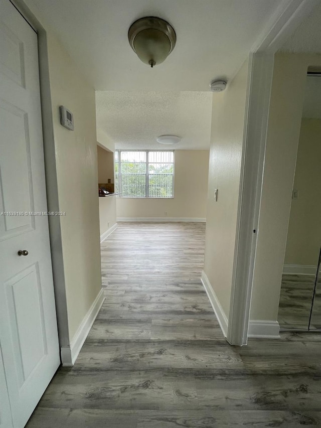 corridor featuring a textured ceiling and hardwood / wood-style floors