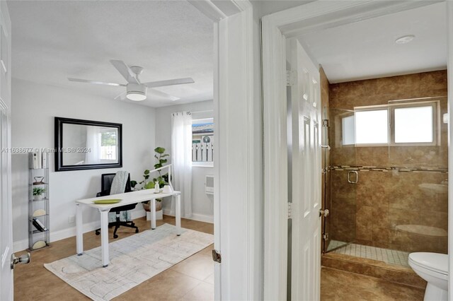 bathroom with toilet, a shower with shower door, ceiling fan, and tile patterned floors