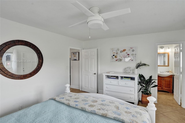 bedroom featuring ceiling fan, light tile patterned floors, ensuite bathroom, and a sink