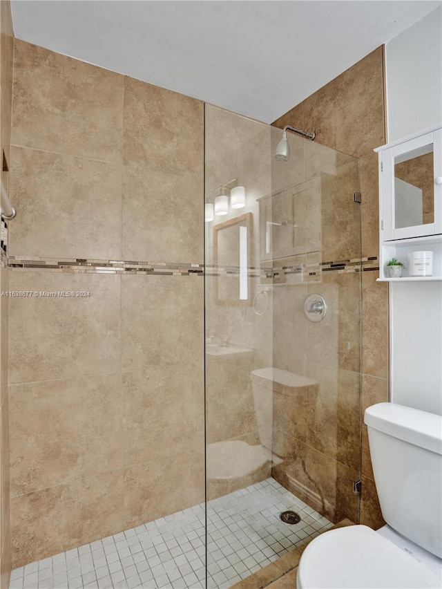 bathroom featuring toilet and tiled shower