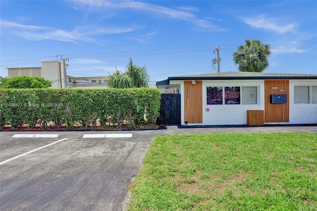 ranch-style home featuring uncovered parking, a front yard, and fence