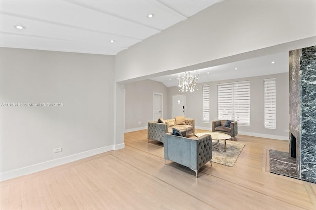 living room featuring light hardwood / wood-style floors, a chandelier, and a fireplace