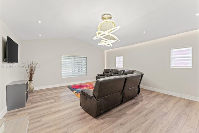 living room featuring lofted ceiling, a notable chandelier, and light hardwood / wood-style floors