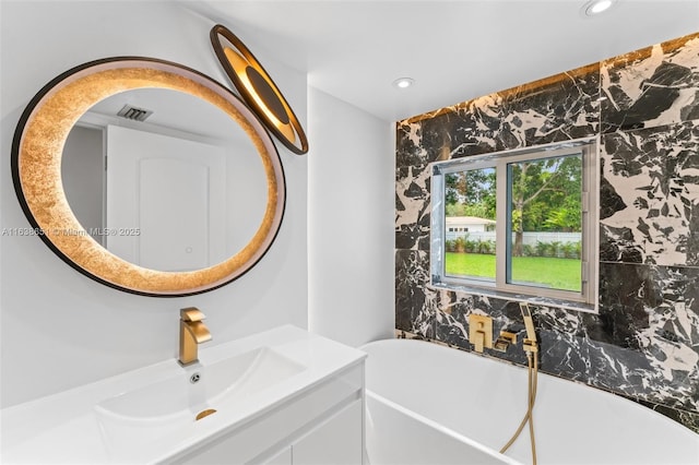 bathroom featuring vanity, tile walls, and a tub to relax in