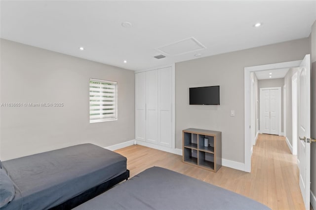 bedroom featuring a closet, light wood-style floors, baseboards, visible vents, and recessed lighting