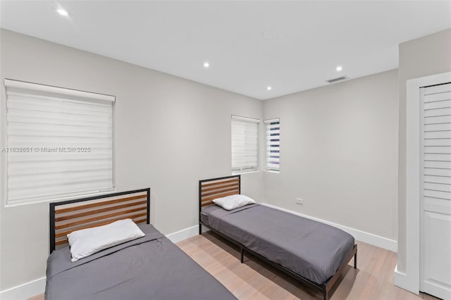 bedroom with recessed lighting, visible vents, light wood finished floors, and baseboards