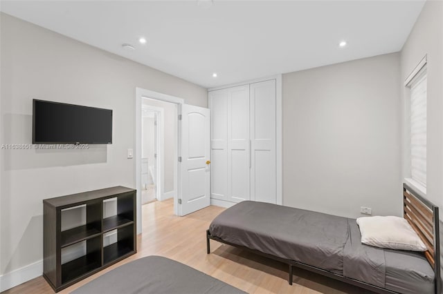 bedroom with recessed lighting, light wood finished floors, and baseboards