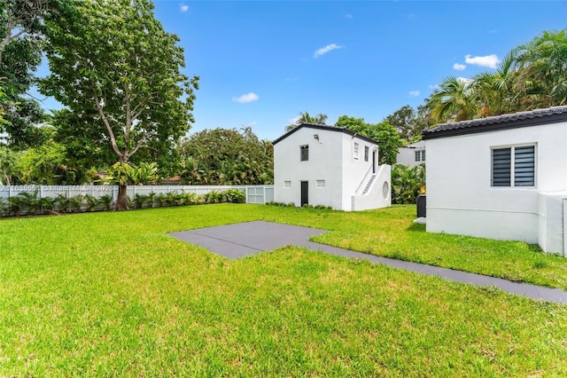 view of yard featuring a patio, a fenced backyard, and stairs