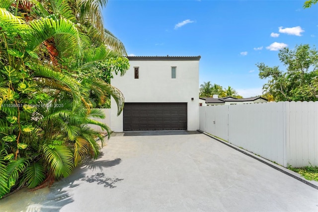 exterior space featuring concrete driveway and fence
