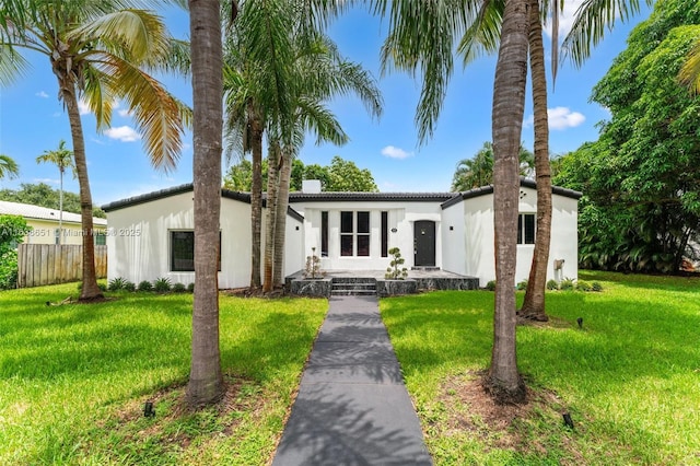 view of front of home featuring stucco siding, fence, and a front yard