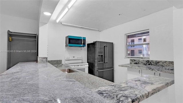 kitchen featuring light stone countertops, electric range, and high quality fridge