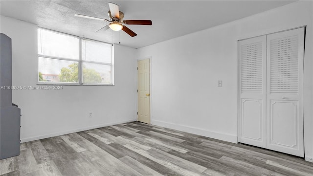 unfurnished bedroom featuring ceiling fan, light hardwood / wood-style flooring, and a closet