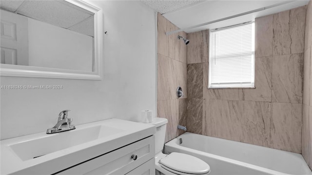 full bathroom with vanity, tiled shower / bath, a wealth of natural light, and toilet