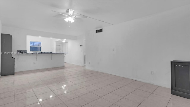 unfurnished living room with ceiling fan and light tile patterned flooring