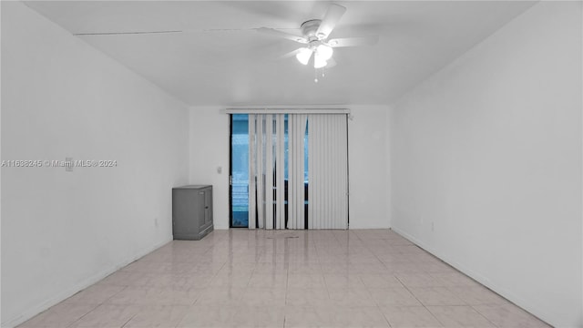 tiled spare room featuring ceiling fan