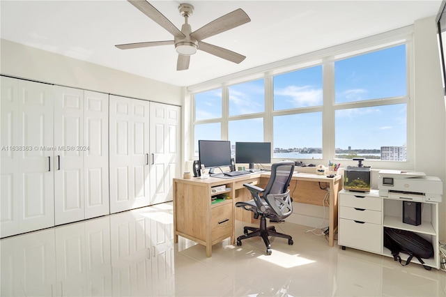 tiled home office with ceiling fan and expansive windows