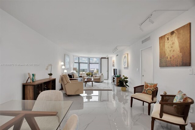 living room featuring a wall of windows, track lighting, and light tile patterned floors