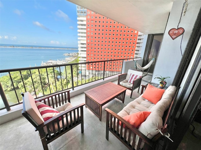 balcony featuring an outdoor living space and a water view