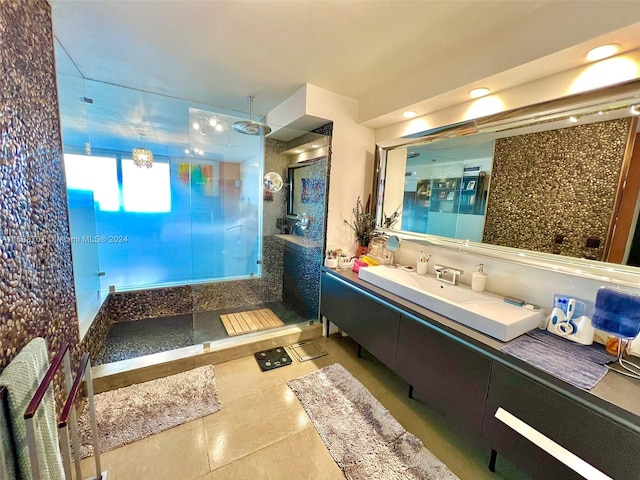 bathroom featuring tile patterned flooring, vanity, and a tile shower