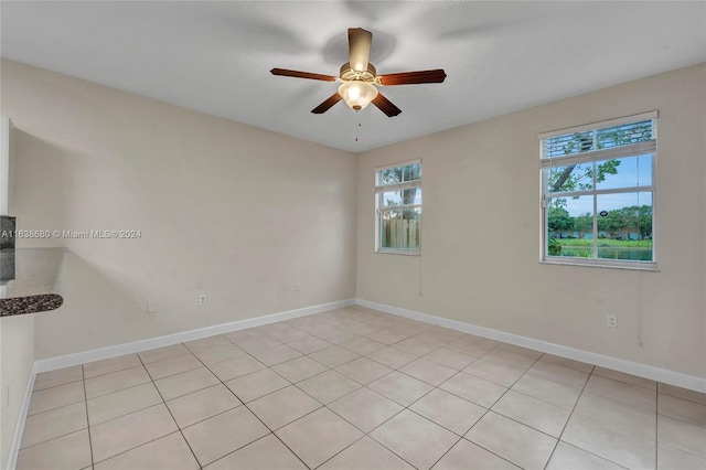 empty room featuring ceiling fan and light tile patterned floors