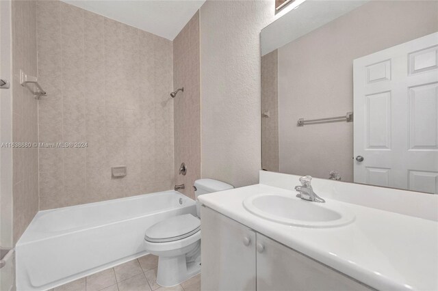 full bathroom with toilet, tiled shower / bath combo, vanity, and tile patterned floors