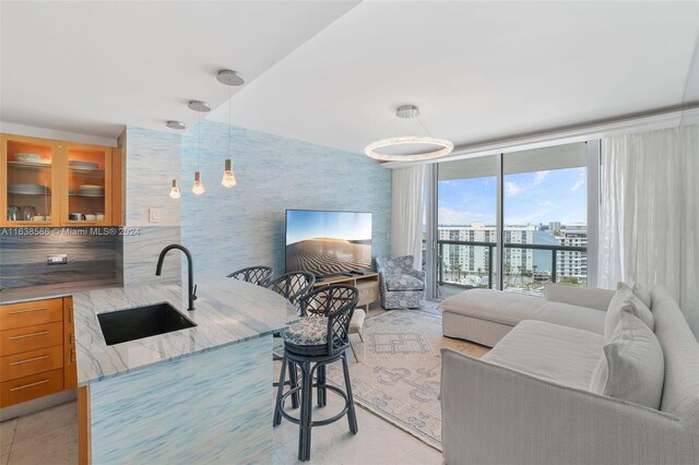 living room with light tile patterned floors, sink, and floor to ceiling windows