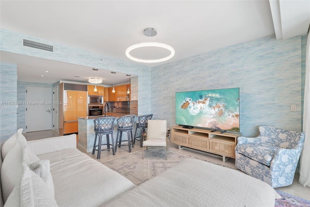 living room featuring visible vents and wallpapered walls