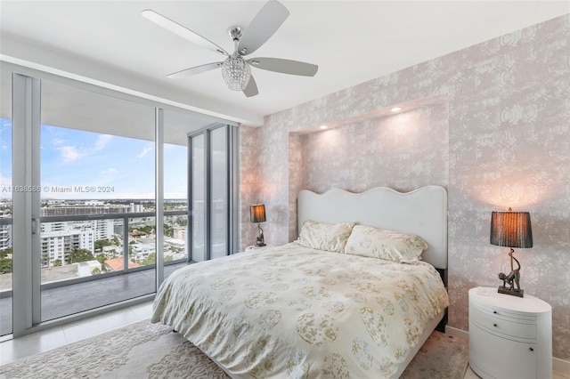 tiled bedroom with wallpapered walls, a wall of windows, access to exterior, and a ceiling fan