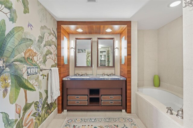 bathroom with tile patterned floors, dual bowl vanity, and a relaxing tiled tub