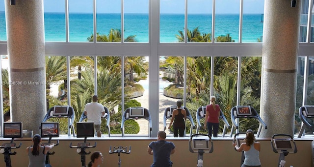 exercise room featuring plenty of natural light and a water view