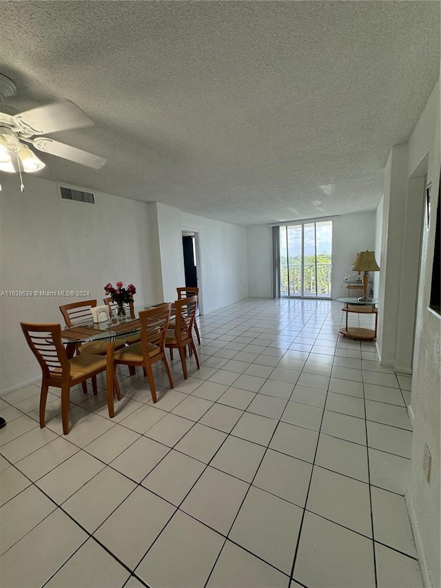 dining room with ceiling fan, a textured ceiling, and light tile patterned floors